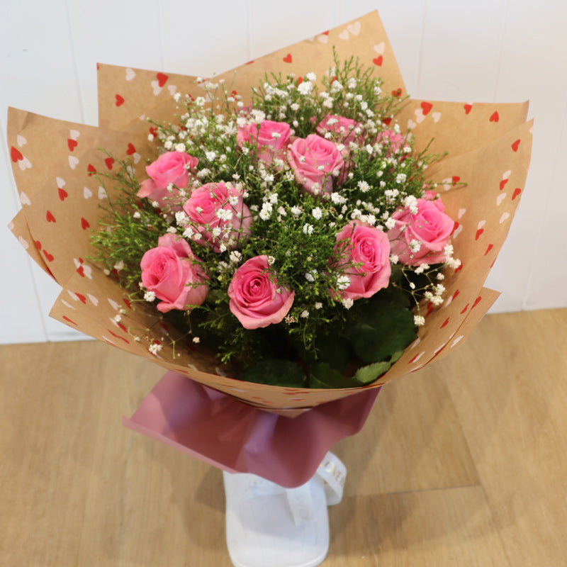 A luxurious bouquet filled with fresh, soft pink roses, a timeless symbol of love and devotion.