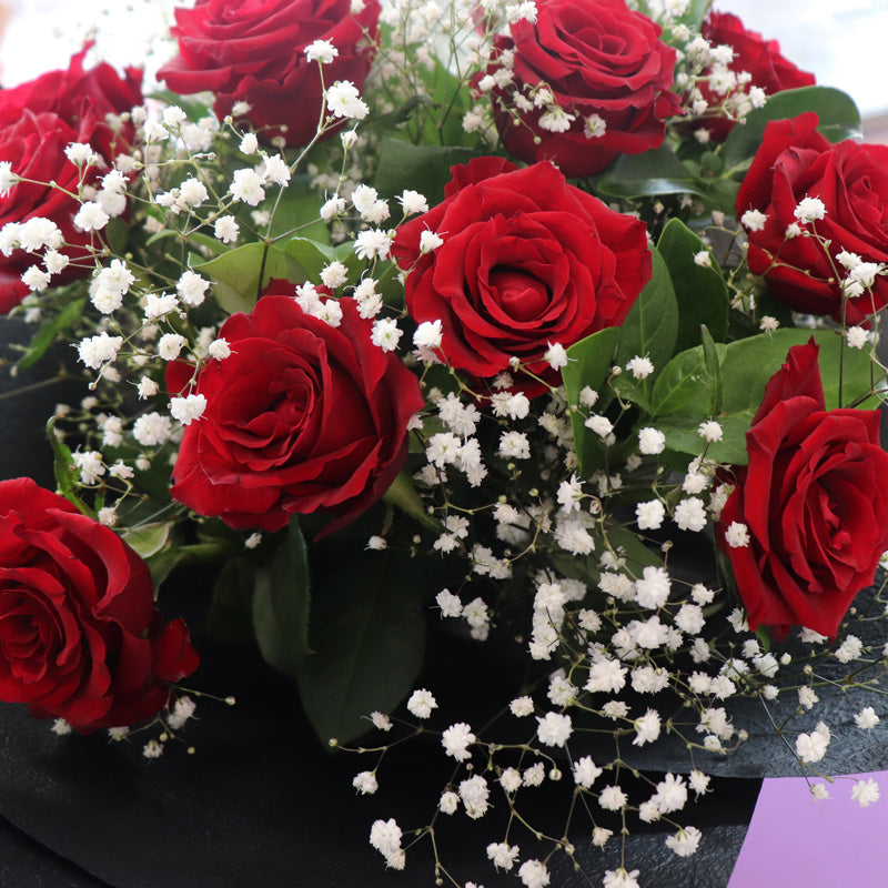 A premium floral bouquet with twelve stunning red roses, elegantly presented for a timeless romantic gesture.
