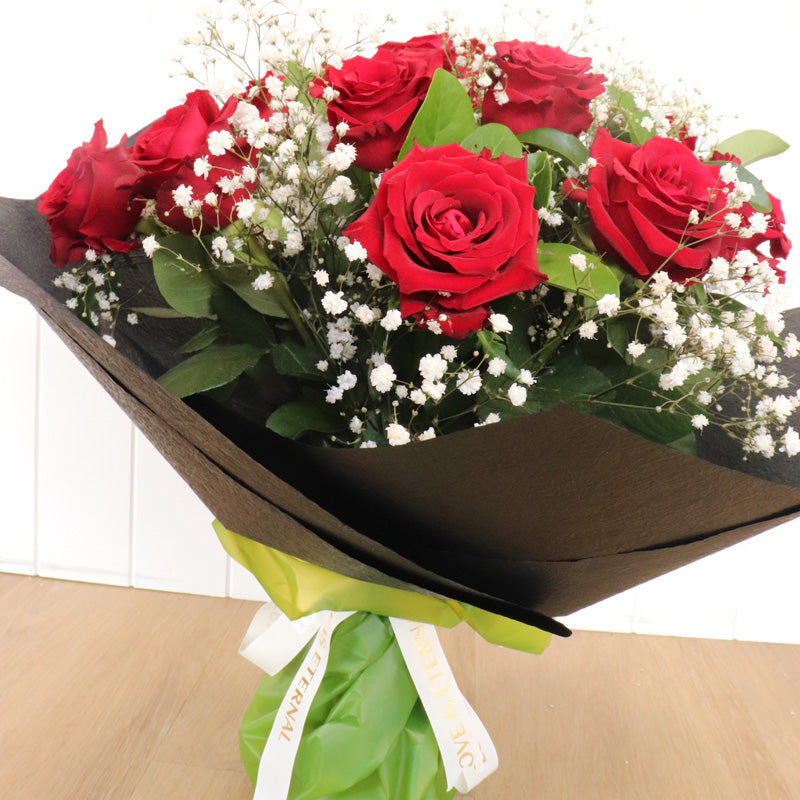 A beautifully crafted bouquet of deep red roses, artistically arranged to convey love and affection.