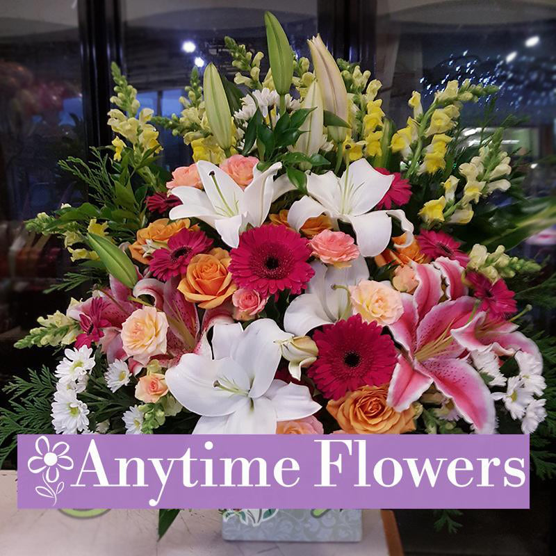 Luxurious floral box with white lilies, pink gerberas, and peach roses.