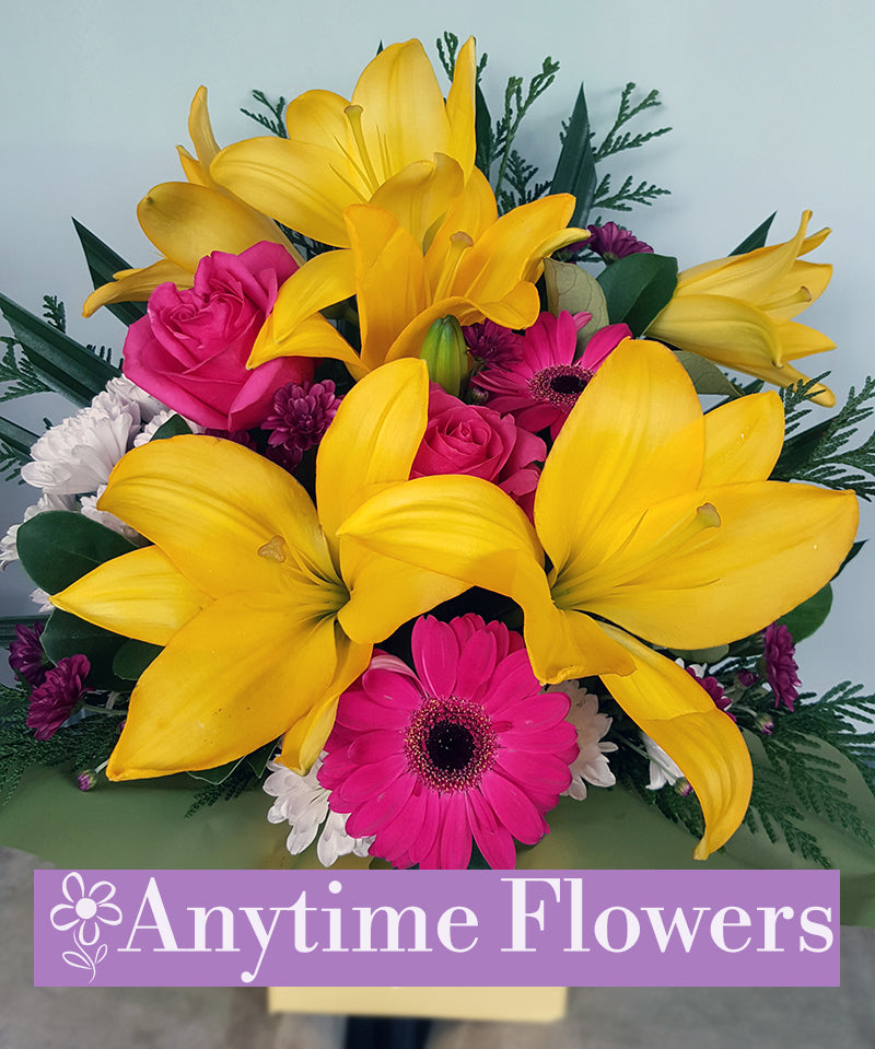 A cheerful arrangement of yellow lilies, pink gerberas, and magenta roses.