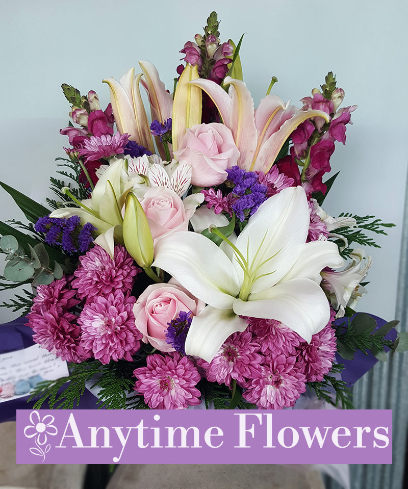 A serene bouquet with pink lilies, purple chrysanthemums, and white oriental lilies.