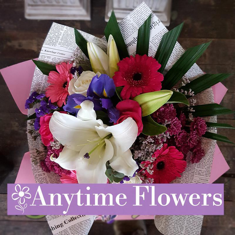 A bright arrangement of lilies, gerberas, and purple irises.