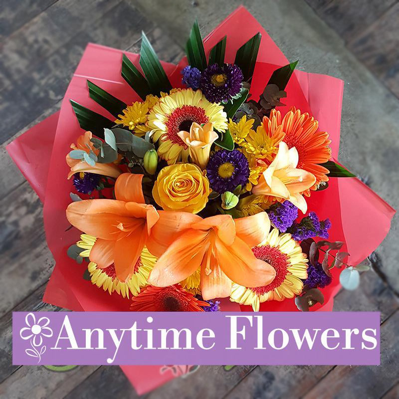 A vibrant mix of orange lilies, golden roses, and gerberas.