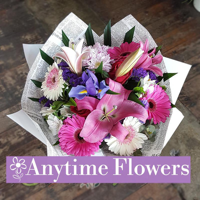 A graceful blend of pink lilies, gerberas, and purple irises.