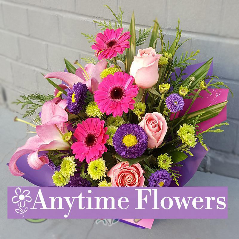 A vibrant bouquet with gerberas, roses, and asters in a mix of bright colours.