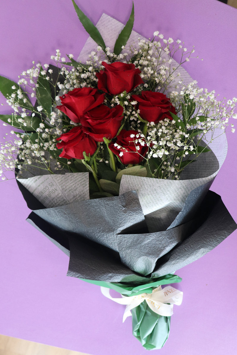 A refined floral bouquetarrangement with six luxurious red roses, ideal for making an unforgettable romantic gesture.