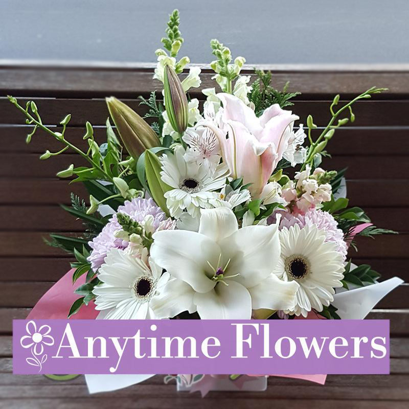 Bouquet with white lilies, gerberas, and pastel floral accents.