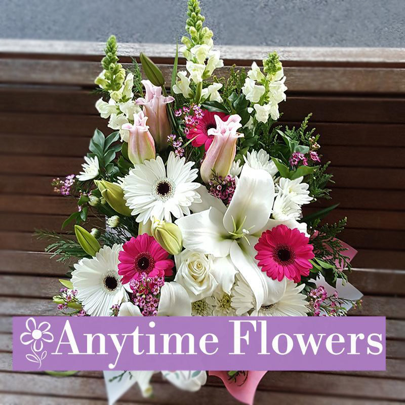 Bright bouquet with pink lilies, gerberas, and snapdragons.