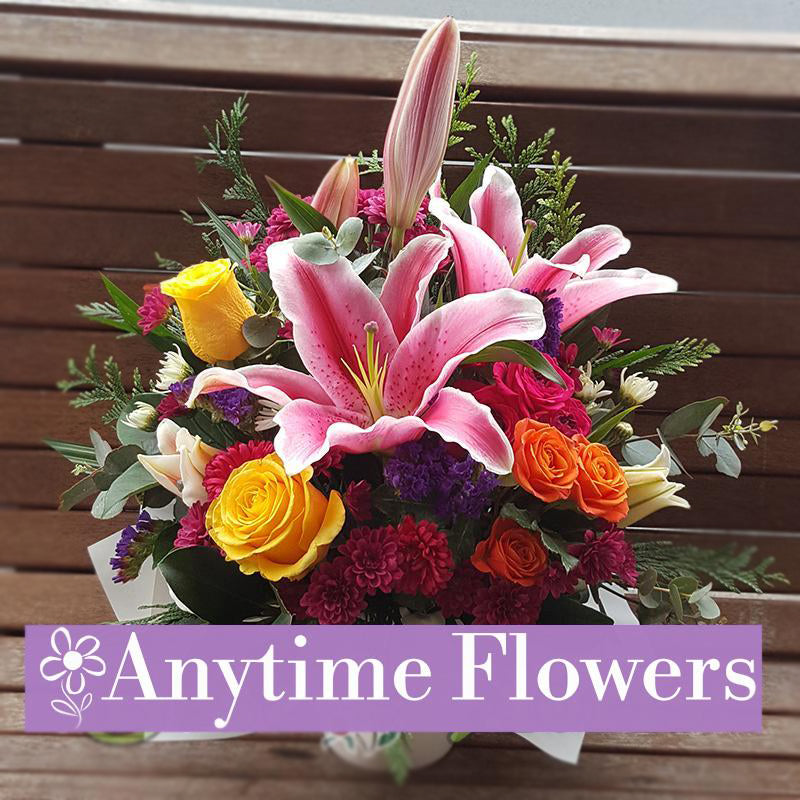 Bouquet with pink lilies, yellow roses, and colourful accents.