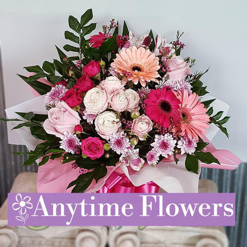 A beautiful bouquet of pink gerberas, roses, and chrysanthemums wrapped in soft pink tones.
