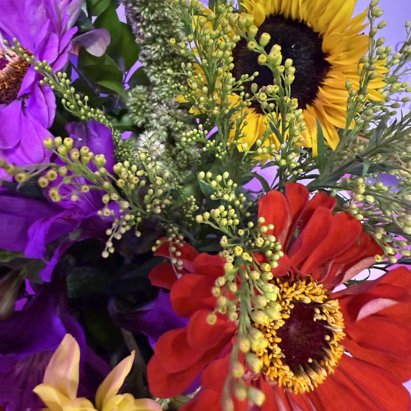 A beautiful mix of sunflowers and vibrant flowers in a mini-box arrangement, ideal for adding color and joy to any space.