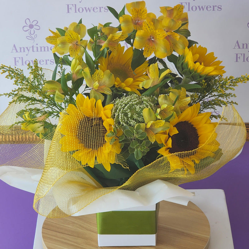 A mini-box arrangement filled with vibrant sunflowers, perfect for bringing cheer and sunshine into any space.