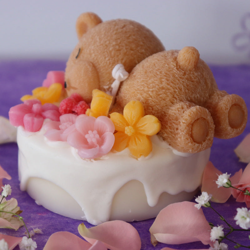 Teddy bear sleeping on a cake with flowers rose scent