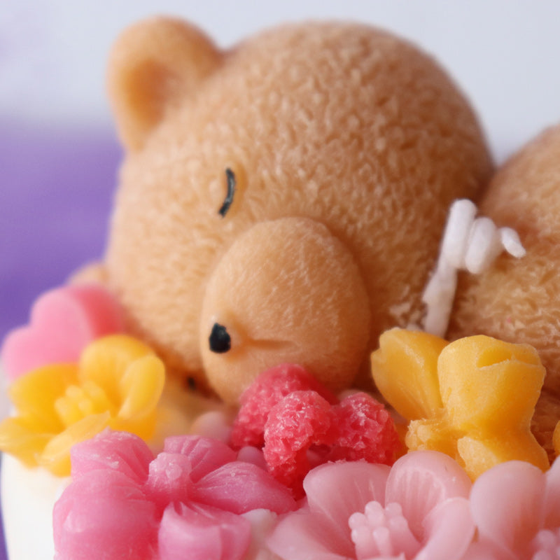 Teddy bear sleeping on a cake with flowers rose scent