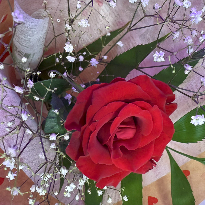 A top-view of a luxurious floral bouquet with vibrant a red rose, perfect for expressing love and affection.