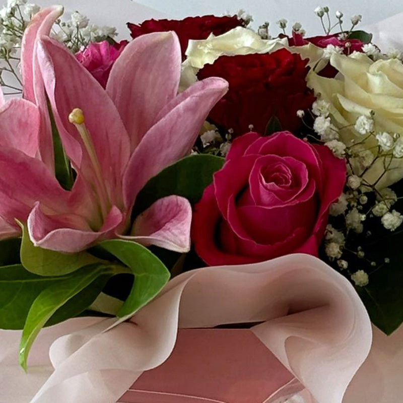 A close-up shot of the Lily & Rose Delight Box, highlighting the vibrant petals and intricate details of the premium flowers arranged beautifully.