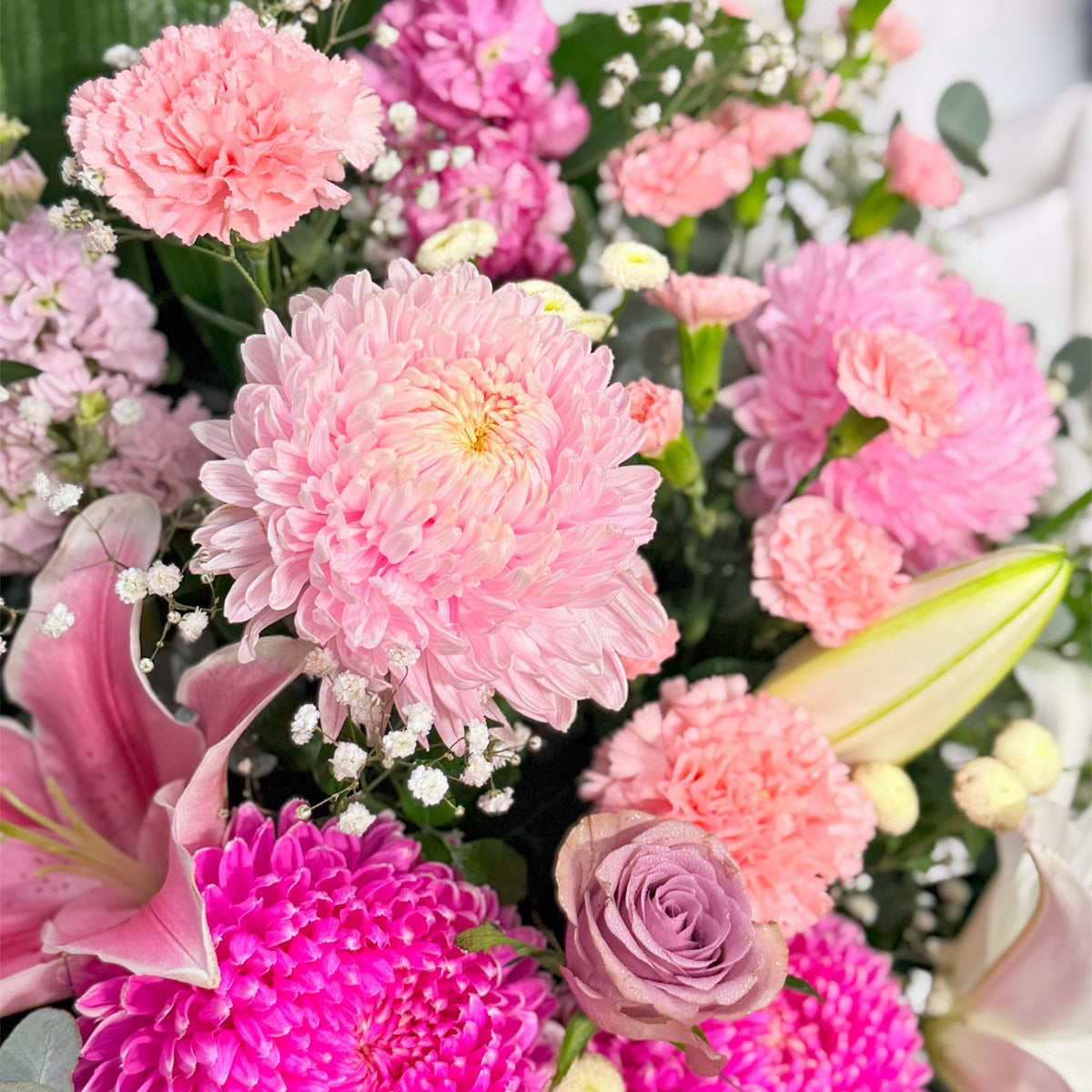Roses, chrysanthemums and lilies in a pink flower arrangement