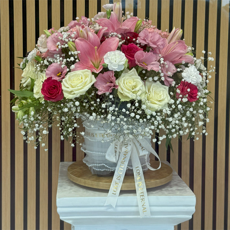 Close-up of The Princess arrangement, showcasing the intricate blend of pink and white blooms with velvety roses and lush greenery.