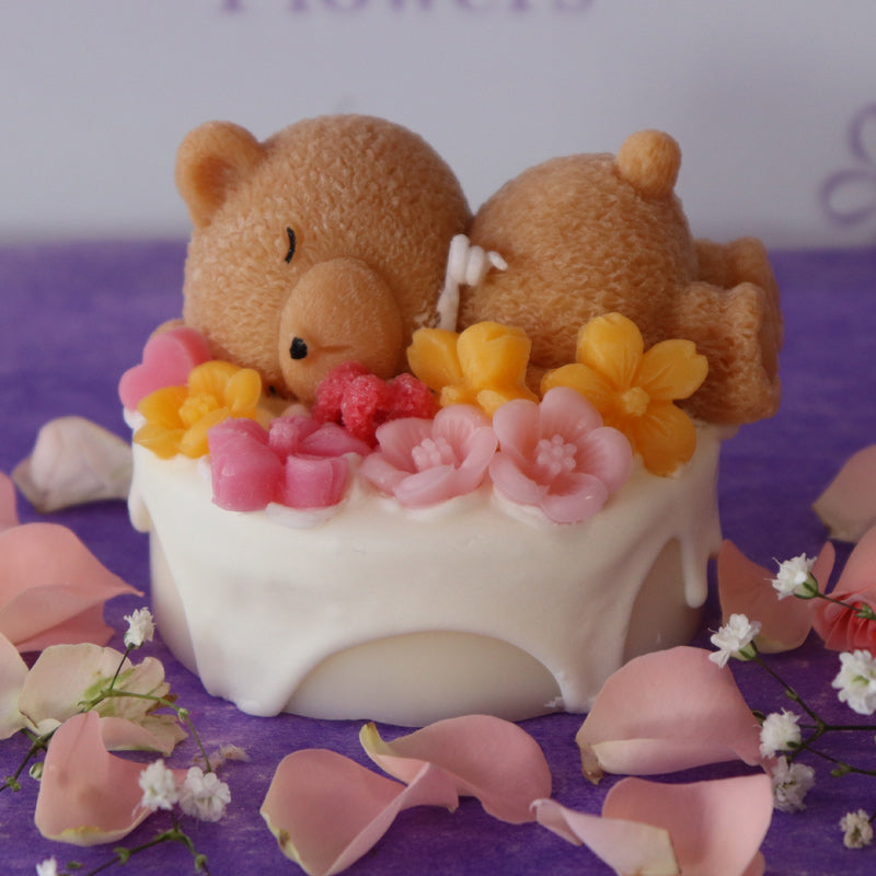 Teddy bear sleeping on a cake with flowers rose scent
